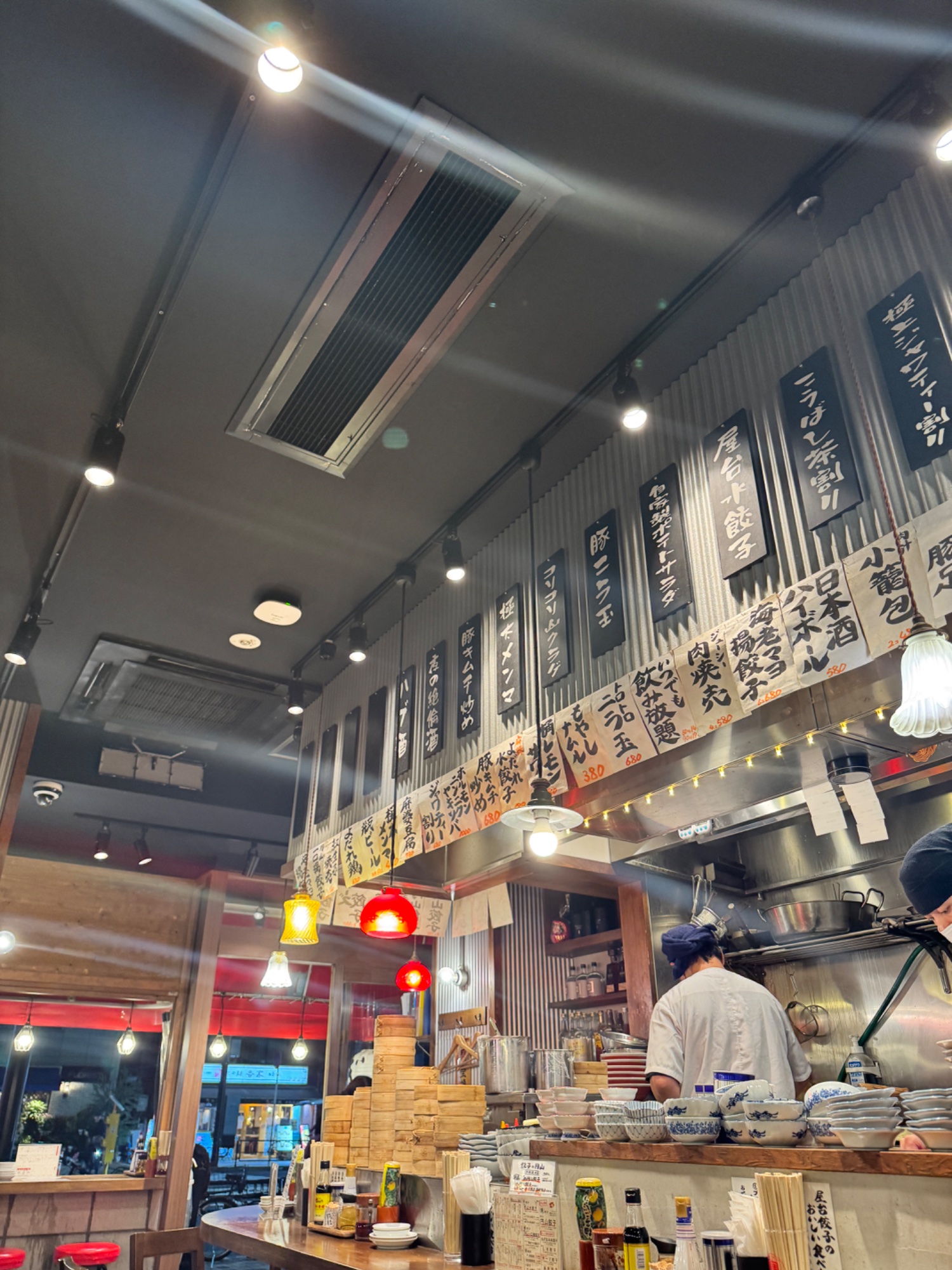 あたたかな灯りのある飲食店の店内で、店主が準備をしている様子